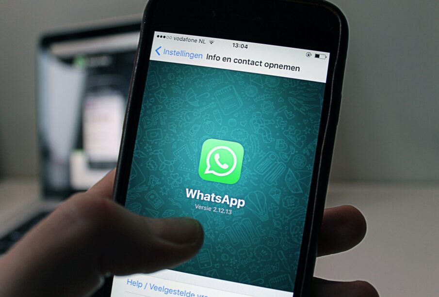 Persona sosteniendo en la mano teléfono móvil con la aplicación de WhatsApp.