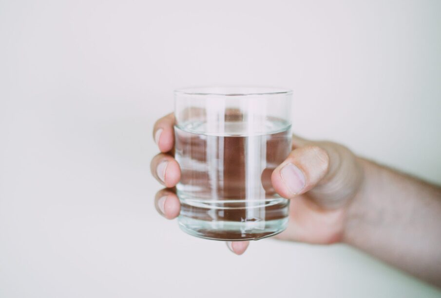 Persona sosteniendo vaso de agua.