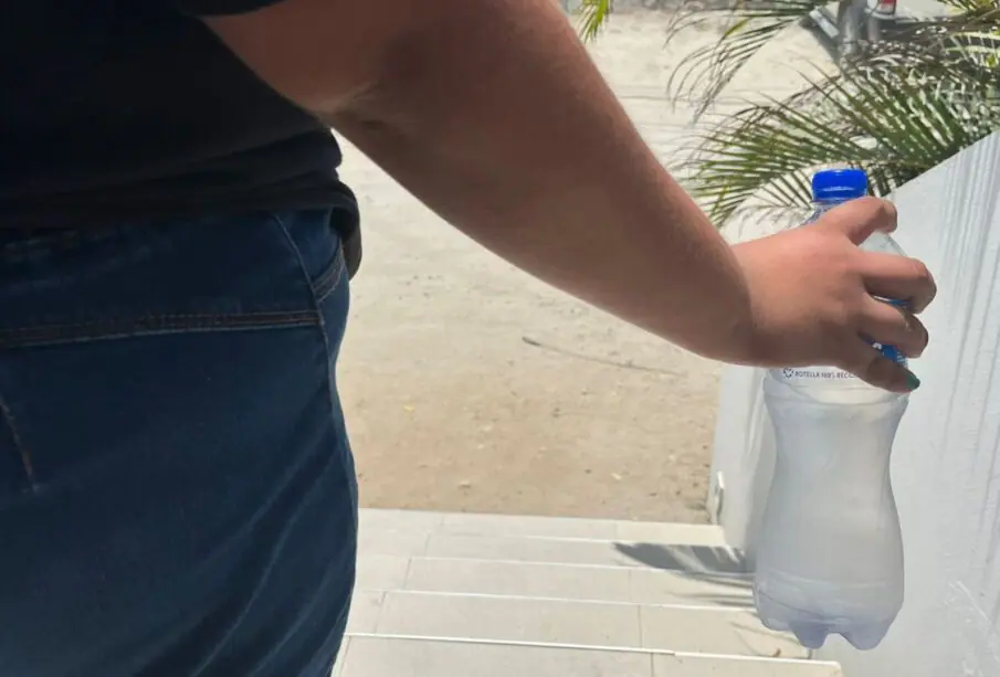 Persona sosteniendo una botella de agua fría.