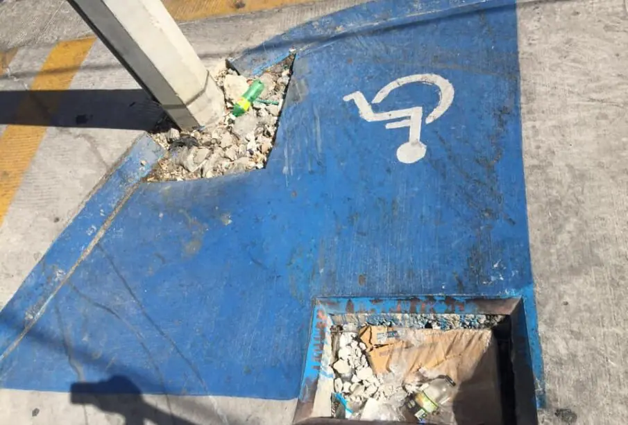 Poste en medio de rampa para personas con discapacidad.