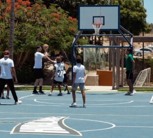 basquetbolistas jungando con niños