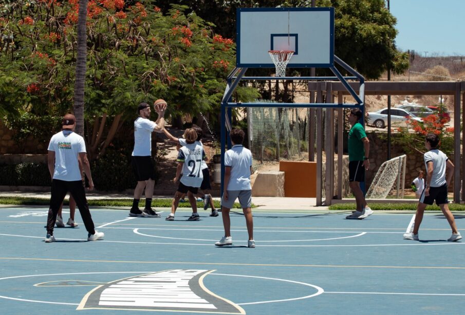 basquetbolistas jungando con niños