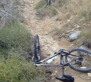 bicicleta caída en sendero rocoso