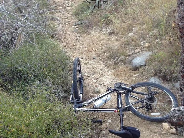 bicicleta caída en sendero rocoso