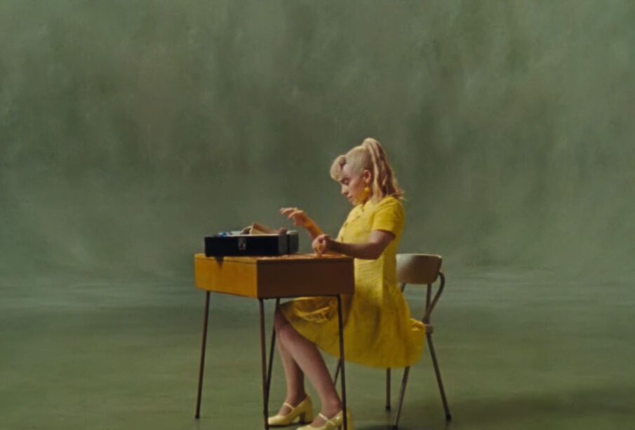 Una captura de pantalla del video musical "What Was I Made For?" de Billie Eilish, donde usa un vestido amarillo.