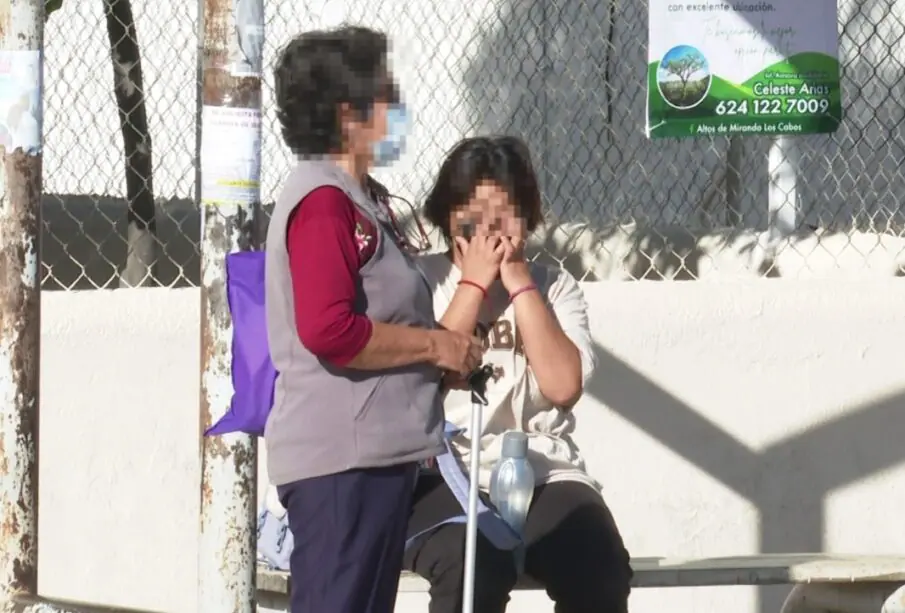Mujer de la tercera edad junto a una joven en la parada de un autobús en Los Cabos.