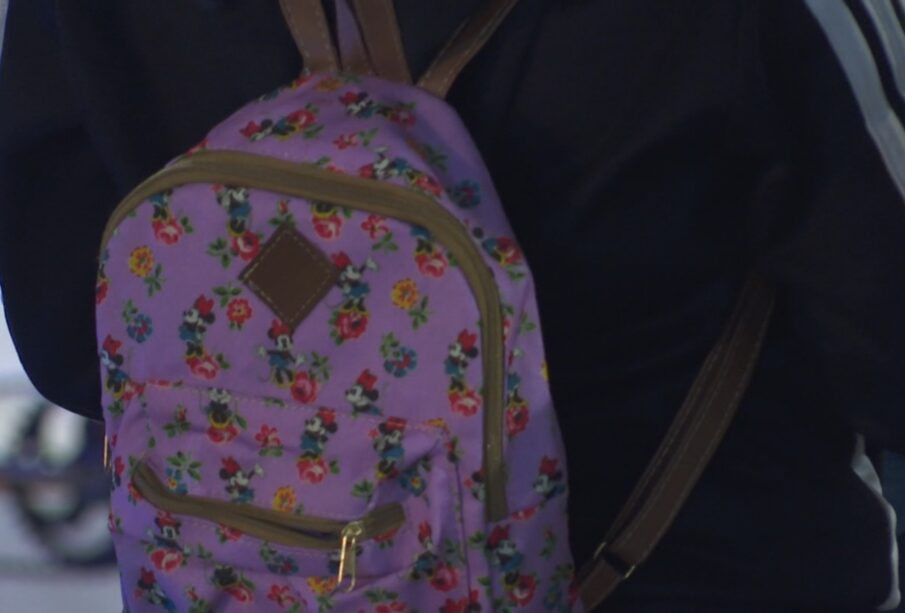 Niña utilizando uniforme de educación física mientras carga su mochila.