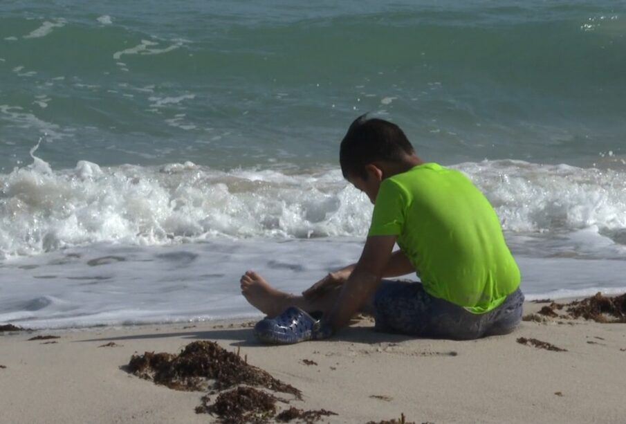 Niño jugando en la playa.