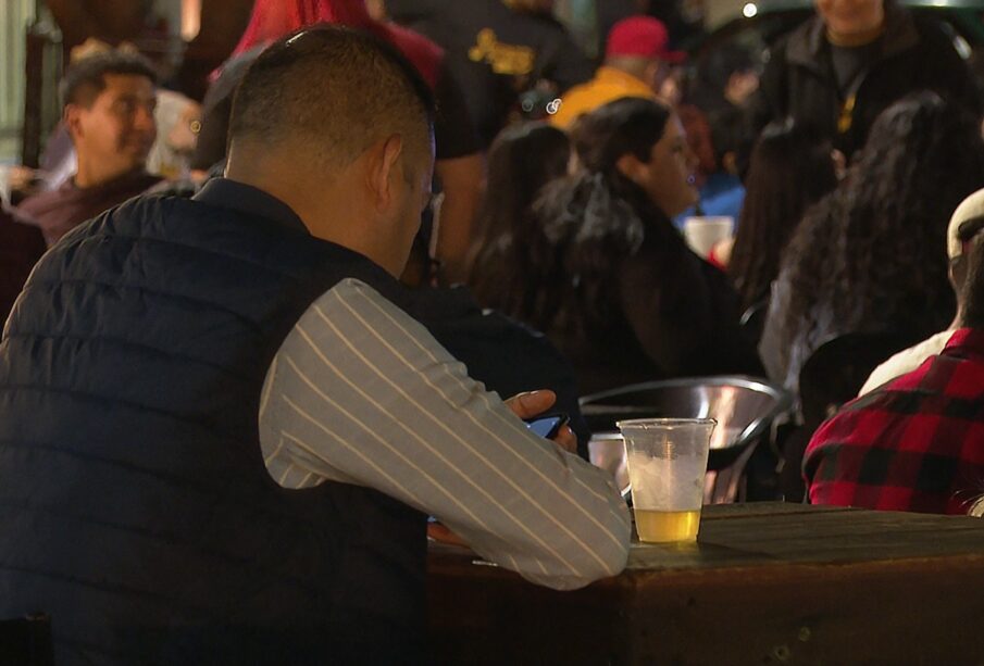 Persona sentada con un vaso de cerveza