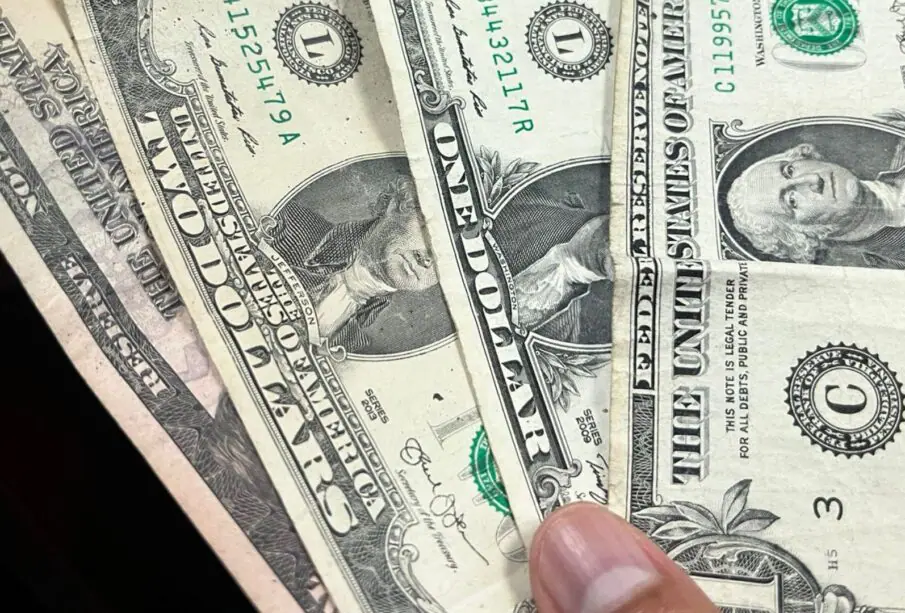 Persona sosteniendo billetes de dólar