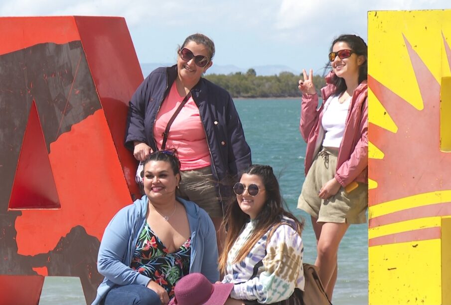 Turistas mujeres tomándose fotos en las letras de La Paz en el malecón.