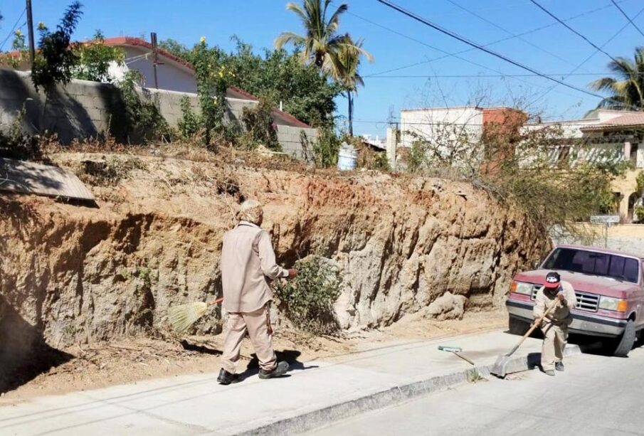 Personas barriendo la calle