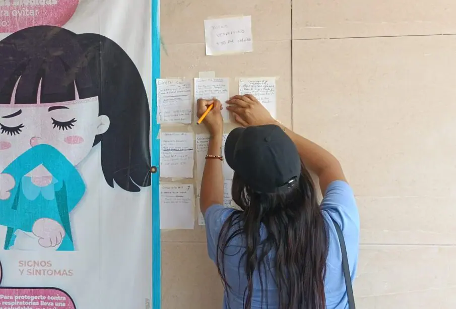 Mujer escribiendo en papeles pegados a la pared