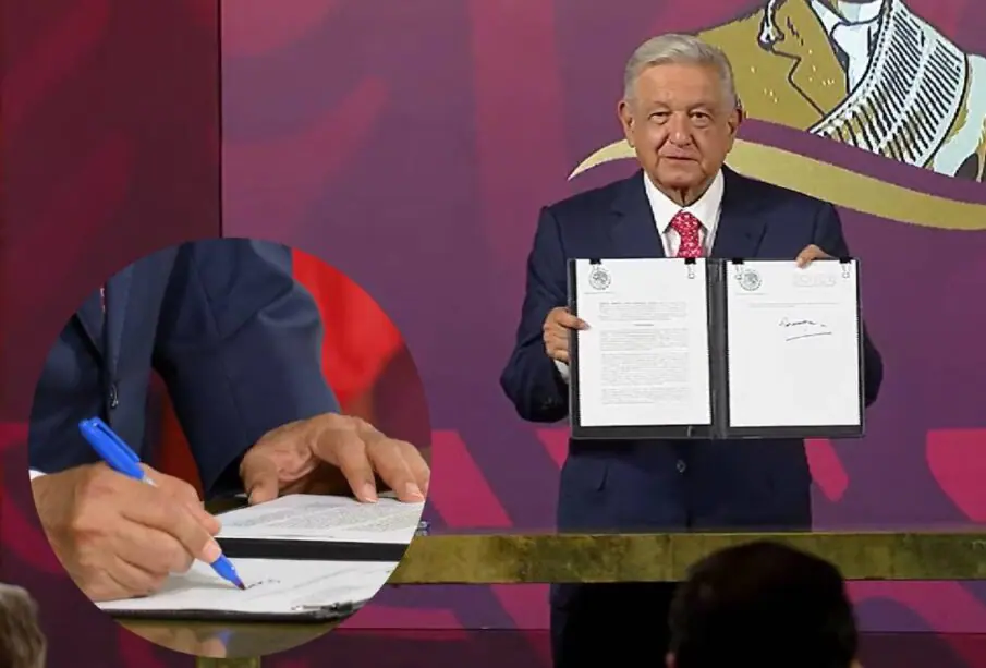 AMLO mostrando decreto y firmándolo