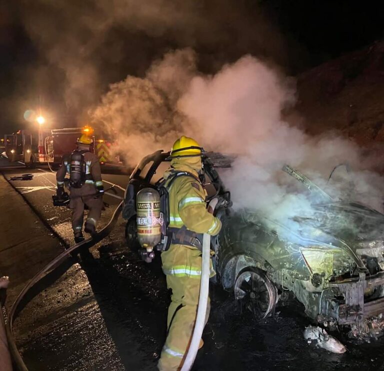 Bomberos apagando incendio en auto