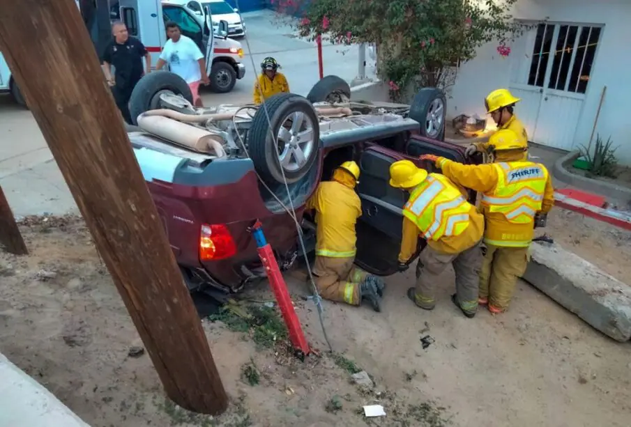 Bomberos sacando a lesionado de carro volcado