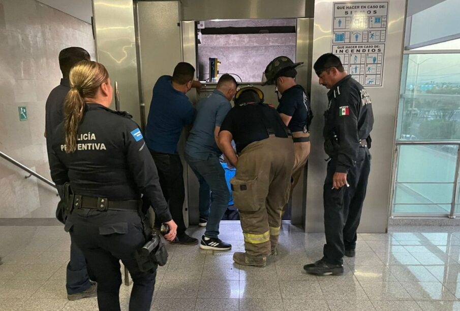 Elementos de la Policía Preventiva rescatando a pareja de adultos mayores de un elevador.