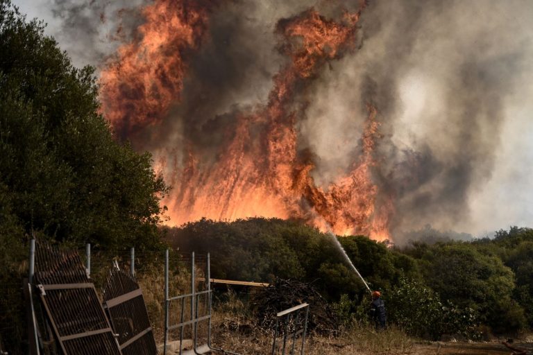 Grecia en llamas y hombre apagando fuego