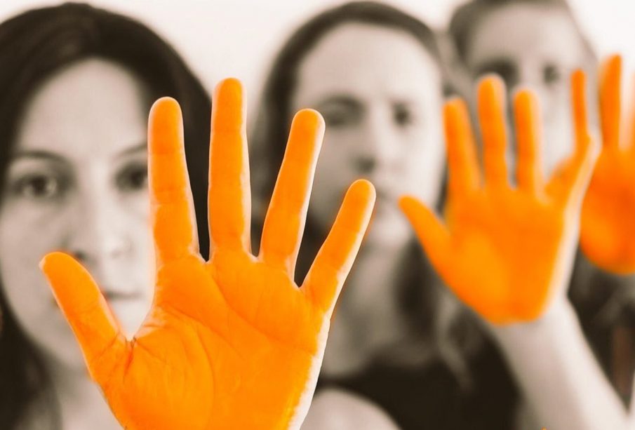 Mujeres con manos pintadas de naranja