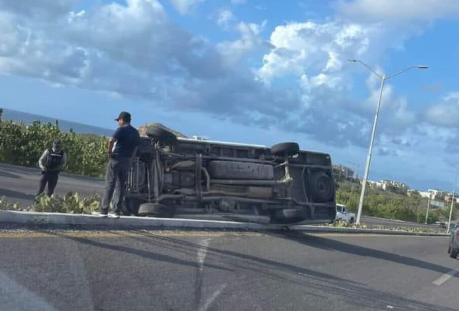 Policía y civiles junto a camioneta tipo panel volcada sobre la carretera Transpeninsular