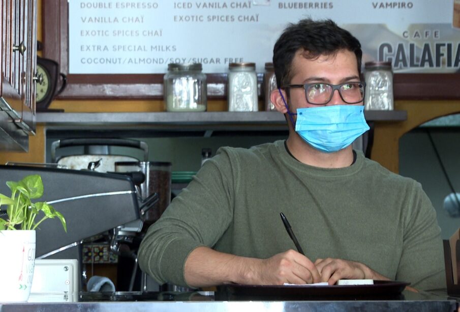 Trabajador de una cafetería usando cubrebocas.