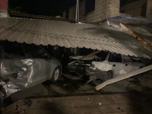 Autos chocados debajo de un tejaban caído 