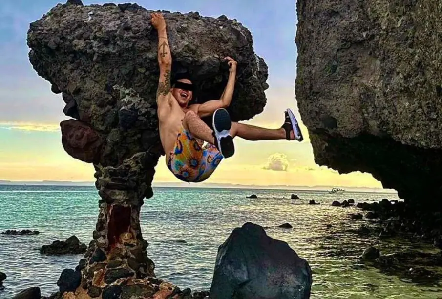 Joven en playa Balandra, se cuelga de roca