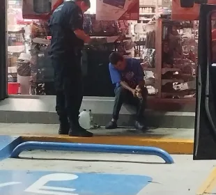 Oficial atendiendo a hombre fuera de una tienda de autoservicio