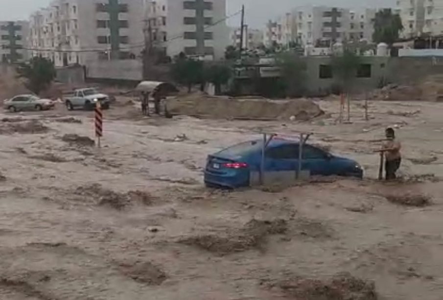 Carro y persona en medio de la corrida de agua