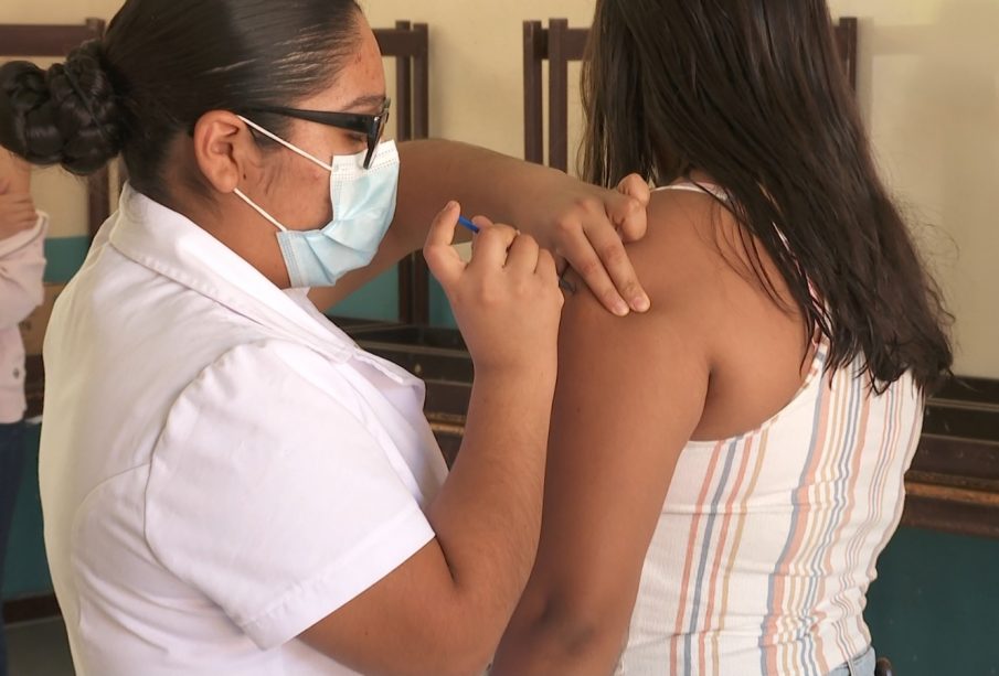 Enfermera vacunando a señorita