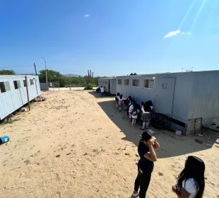 Niños a la sombrea de campers y sentados en bloques