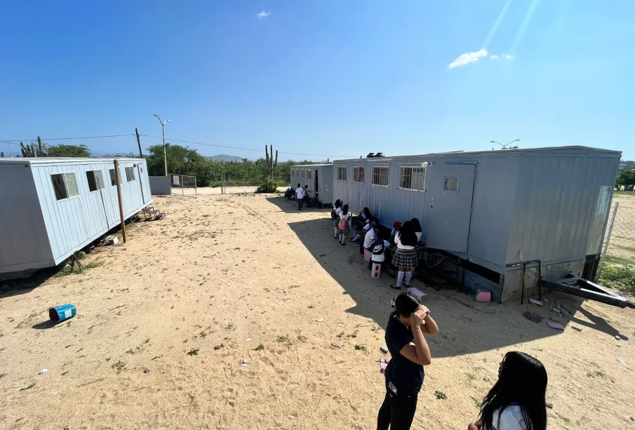 Niños a la sombrea de campers y sentados en bloques