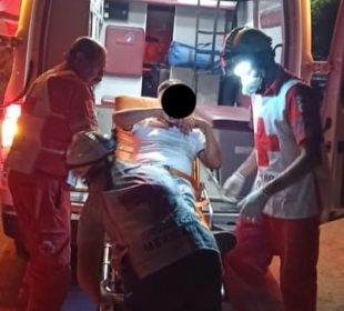 Hombre en camilla siendo antendido por paramédicos de cruz roja