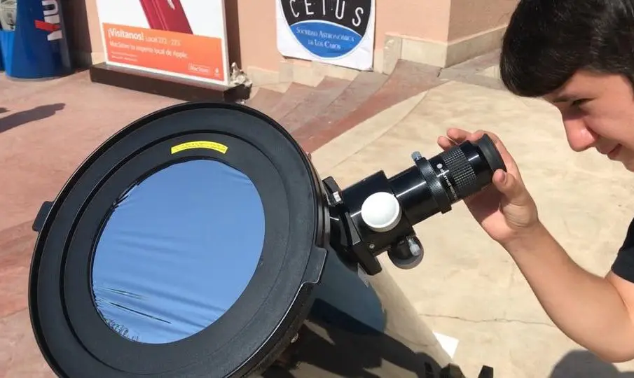 Niños observando a traves de telescopio