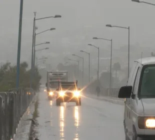 Carros circulando con luces prendidas por lluvia