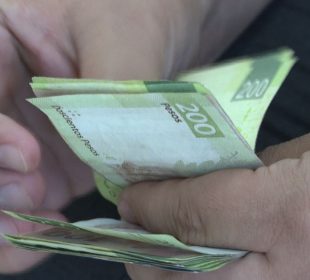 Persona contando billetes de 200 pesos