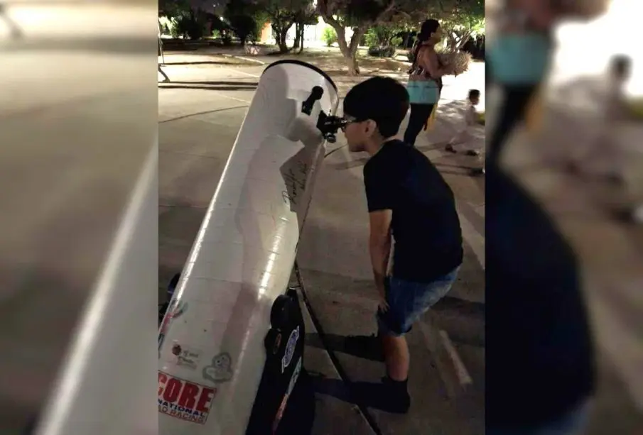 Niño viendo el eclipse por un telescopio