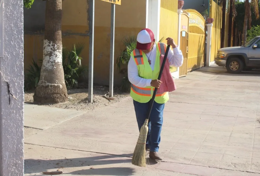 Persona barriendo la calle