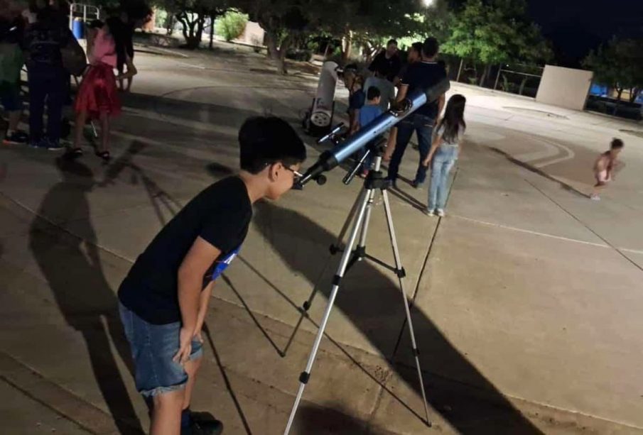 Niño observando el cielo con un telescopio
