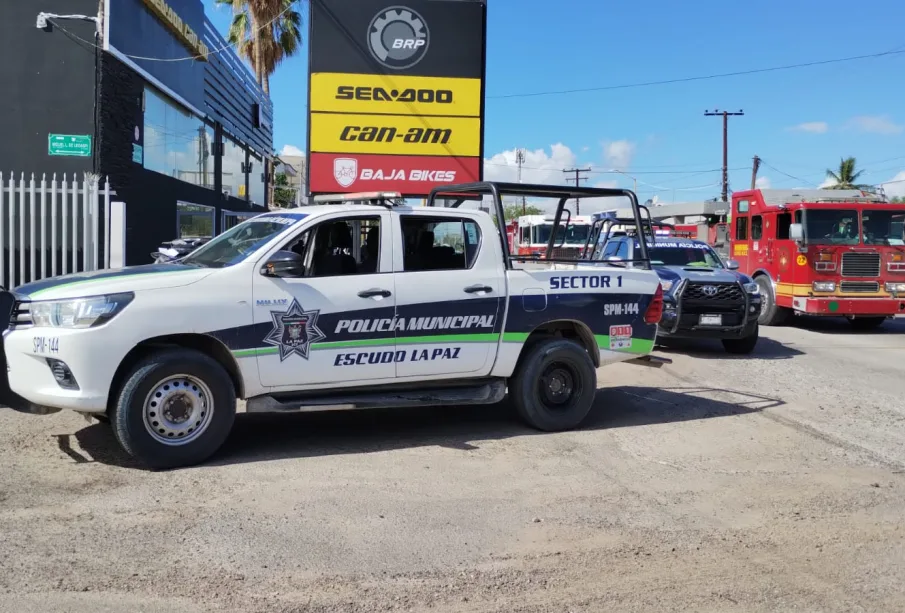 Policía Municipal en agencia de vehículos incendiada.