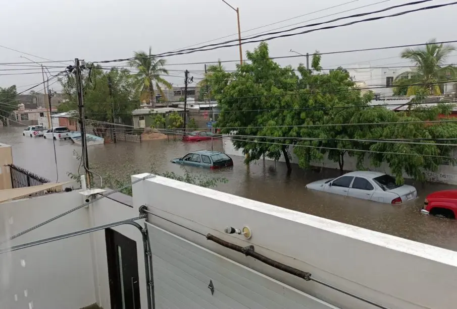 Carros estacionados en calle inundada por lluvia
