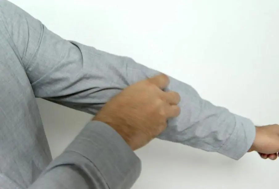 Hombre rascándose el brazo