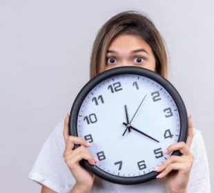 Mujer impresionada sosteniendo reloj