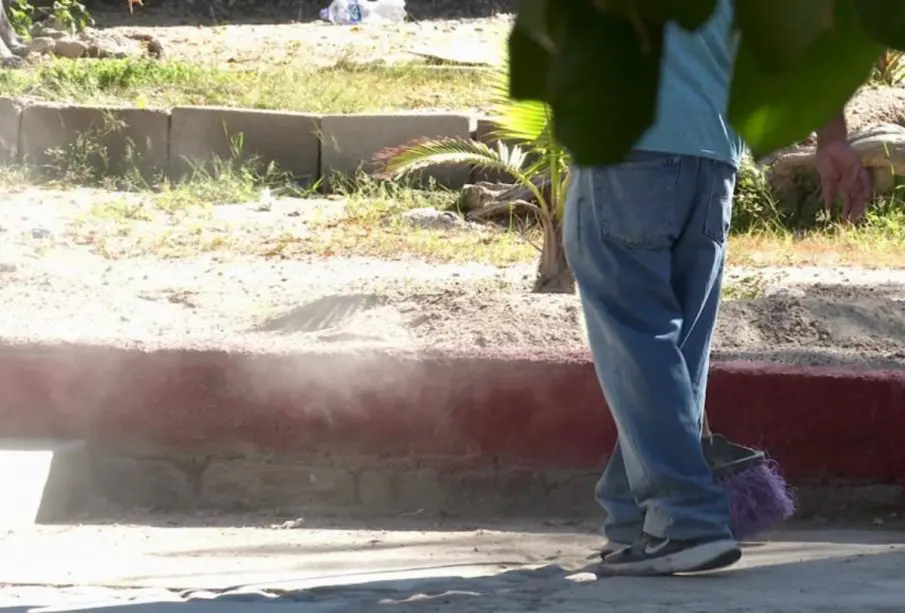 Persona barriendo en escuela de La Paz
