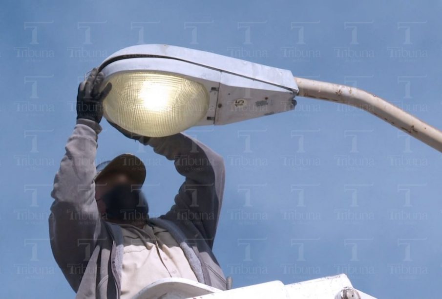 Personal de Servicios Públicos arreglando lámpara en la calle