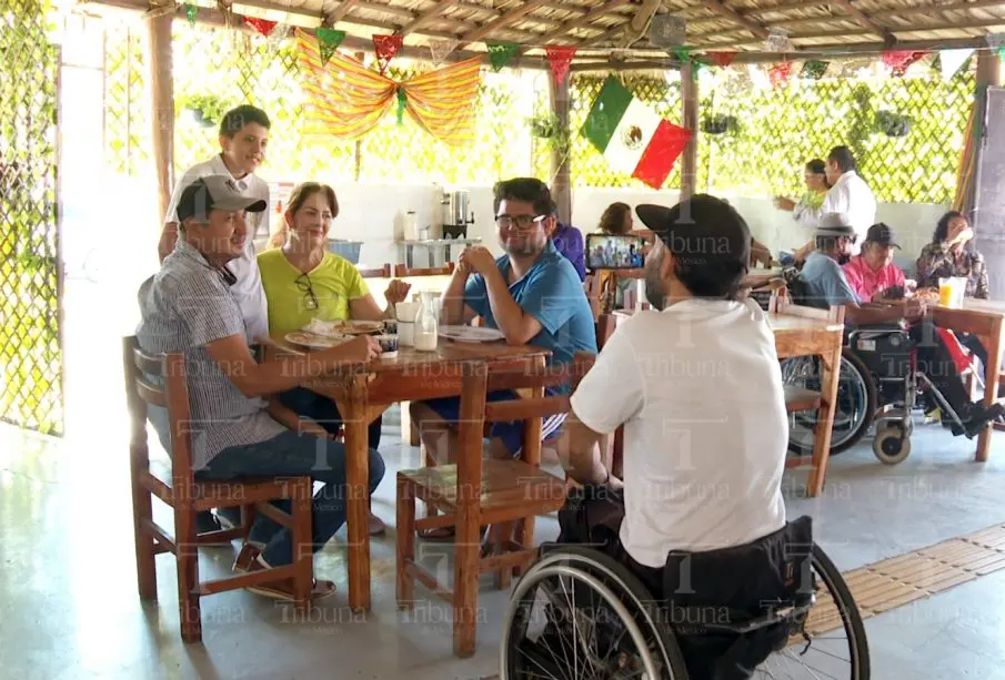 Personas en silla de ruedas atendiendo a comensales
