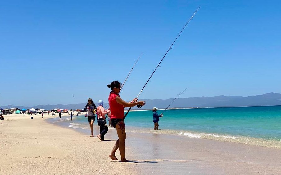 Personas pescando en orilla de playa