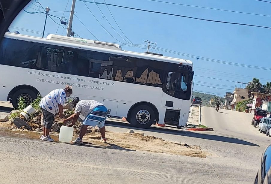 Personas recolectando agua de una fuga