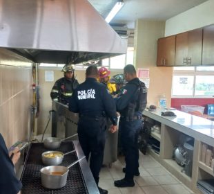 Policias y Bomberos en área de cocina por fuga