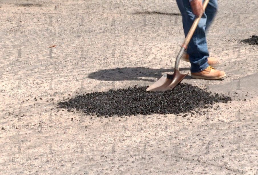 Trabajador tapando bache de la calle